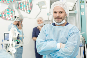 Obraz premium Cheerful professional surgeon posing confidently in an operating theatre