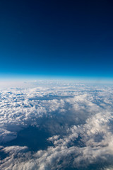 Fototapeta na wymiar 碧い雲と空が美しい、航空機より雲の上よりの風景