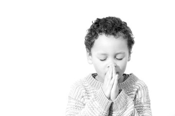 little boy praying to God with hands held together