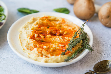 Hummus with paprika, pine seeds and lebanese bread (pita), healthy vegetarian oriental chickpea dish, homemade hummus