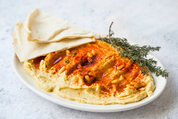 Hummus with paprika, pine seeds and lebanese bread (pita), healthy vegetarian oriental chickpea dish, homemade hummus