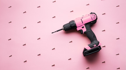 Creative provocation: a pink screwdriver on a pink background and small pink screws.