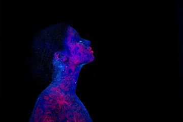 Profile portrait of a beautiful girl alien. Ultraviolet body art blue night sky with stars and pink jellyfish, Girl looking up