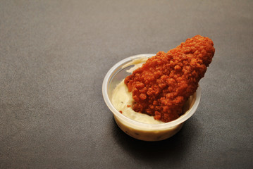 Fried Breaded Fish in Sauce Over a Dark Background 
