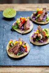 Beef steak tortillas with avocado, sweet corn, tomato salsa and red cabbage