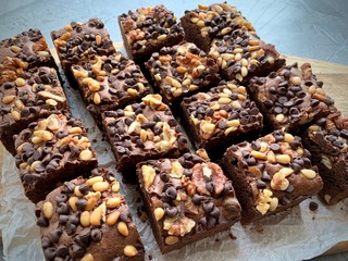 Brownie cubes with chocolate pieces and nuts, top view.