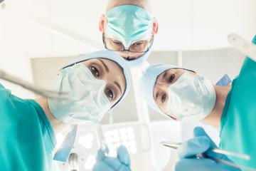 Doctors in operation theater looking at patient