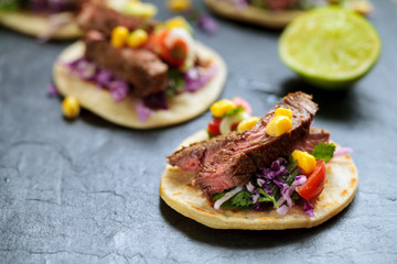 Beef steak tortillas with avocado, sweet corn, tomato salsa and red cabbage