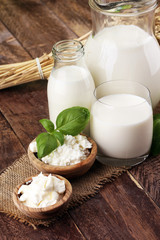 milk products. tasty healthy dairy products on a table. sour cream in a white bowl, cottage cheese bowl, cream in a a bank and milk jar, glass bottle and in a glass