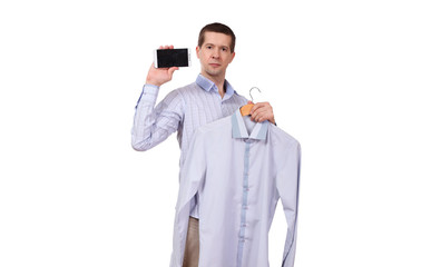 the man holds a coat hanger with a shirt and phone on a white background