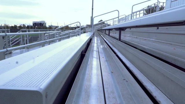 Camera rising up through bleachers.