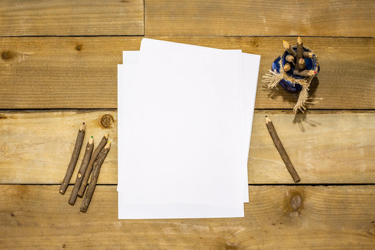 Raw Wood Colored Pencils In A Blue Jar With Burlap Tie And White Paper For Your Message On A Rustic Distressed Wooden Background