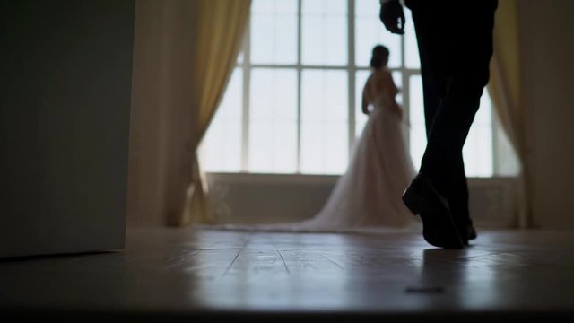 A bride and groom see each other for the first time on their wedding day and share a first look moment before the ceremony. The groom sees the bride for the first time on the wedding day