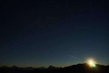 Fototapeta na wymiar Moonrise and starry sky on Altipiano delle Pale di San Martino di Castrozza, Primiero, Dolomiti.