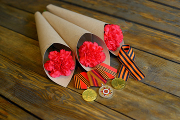 Only EDITORIAL. Moscow, Russia, may 31, 2018: red carnation and St. George ribbon on a wooden...