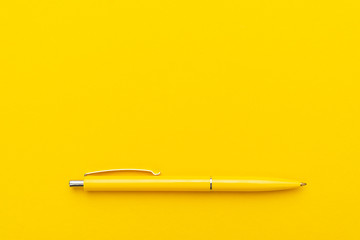 yeloow ballpoint pen on the yellow background