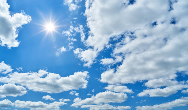 Blue sky with sun and white clouds