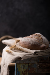 Fresh homemade bread on a gray-blue background, with flax seeds on whole wheat flour. French bread round shape. Bread baking. Unleavened bread