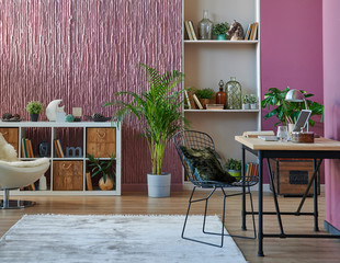 Claret red wall background with bookshelf and table.