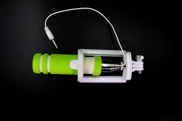 an extensible selfie stick with an adjustable clamp on the end on a white background