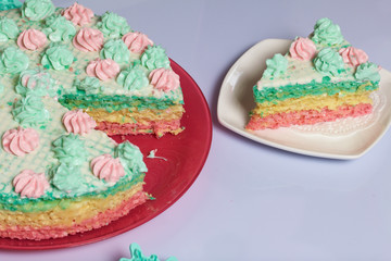 The piece is cut off and lies side by side on a saucer. Waffle cake made from cream soaked cakes. Decorated with cream flowers.