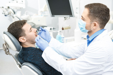 Young man visiting dentist at the clinic