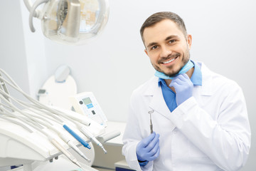 Handsome male professional dentist at his office
