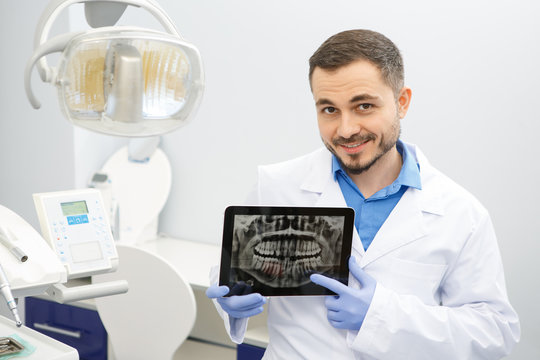 Professional male dentist using a digital tablet at work