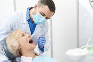 Professional dentist and his senior patient