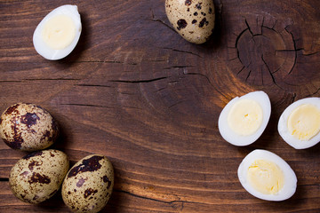 quail eggs in a plate on dark wooden background. copy space. top view