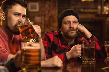 Depressed man drinking beer at the bar
