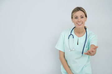 Smiling nurse looking at camera on grey background