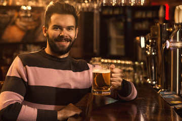 Young man relaxing at the pub having beer