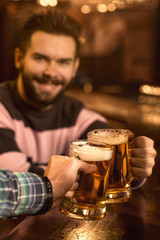 Point of view shot of a man clinking glasses with his friend at the bar
