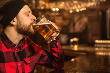Young man enjoying drinking beer at the pub