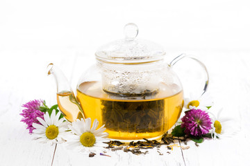 fragrant herbal tea in a glass teapot on white background