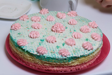 Waffle cake made from cream soaked cakes. Decorated with cream flowers.