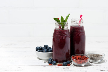 healthy berry smoothies with chia seeds and goji berries on white background
