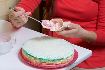 A woman puts a cream in a pastry bag. Round wafer cakes of different colors. For making waffle cake. Nearby there is a can of condensed milk to soak the cakes.