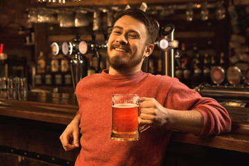 Young man relaxing at the pub having beer