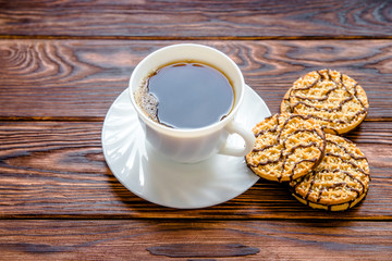 Coffee with biscuits on brown wooden background 