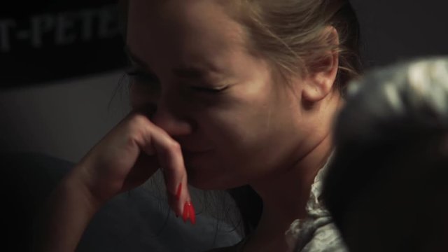 closeup fancy girl with casual makeup and tail hairstyle tries to cope with pain by flinching face during making tattoo