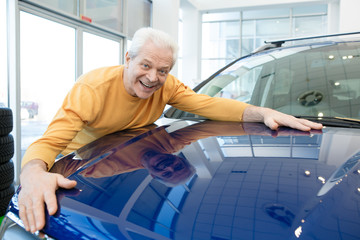Senior man buying a new car at the dealership