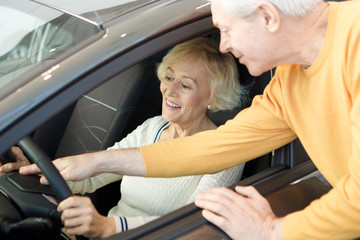 Happy loving senior couple choosing a new car to buy