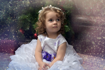 girl little princess in a white festive dress with a blue belt