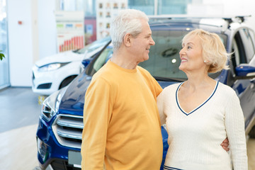 Obraz premium Happy loving senior couple choosing a new car to buy