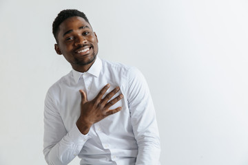 Grateful happy pleased african man holding hands on chest to heart feeling love appreciation...