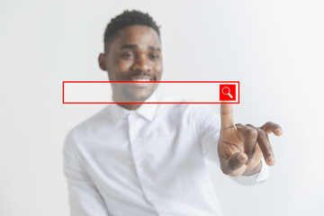 Handsome businessman pointing his finger to the camera and slicking virtual button, finger is in focus while his face is out of focus. Shallow depth of field. Young african american guy interacts with