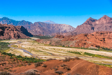 Red mountains landscape with a dry river down the valley