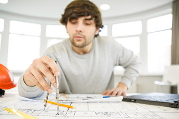 Young male architect working at his office